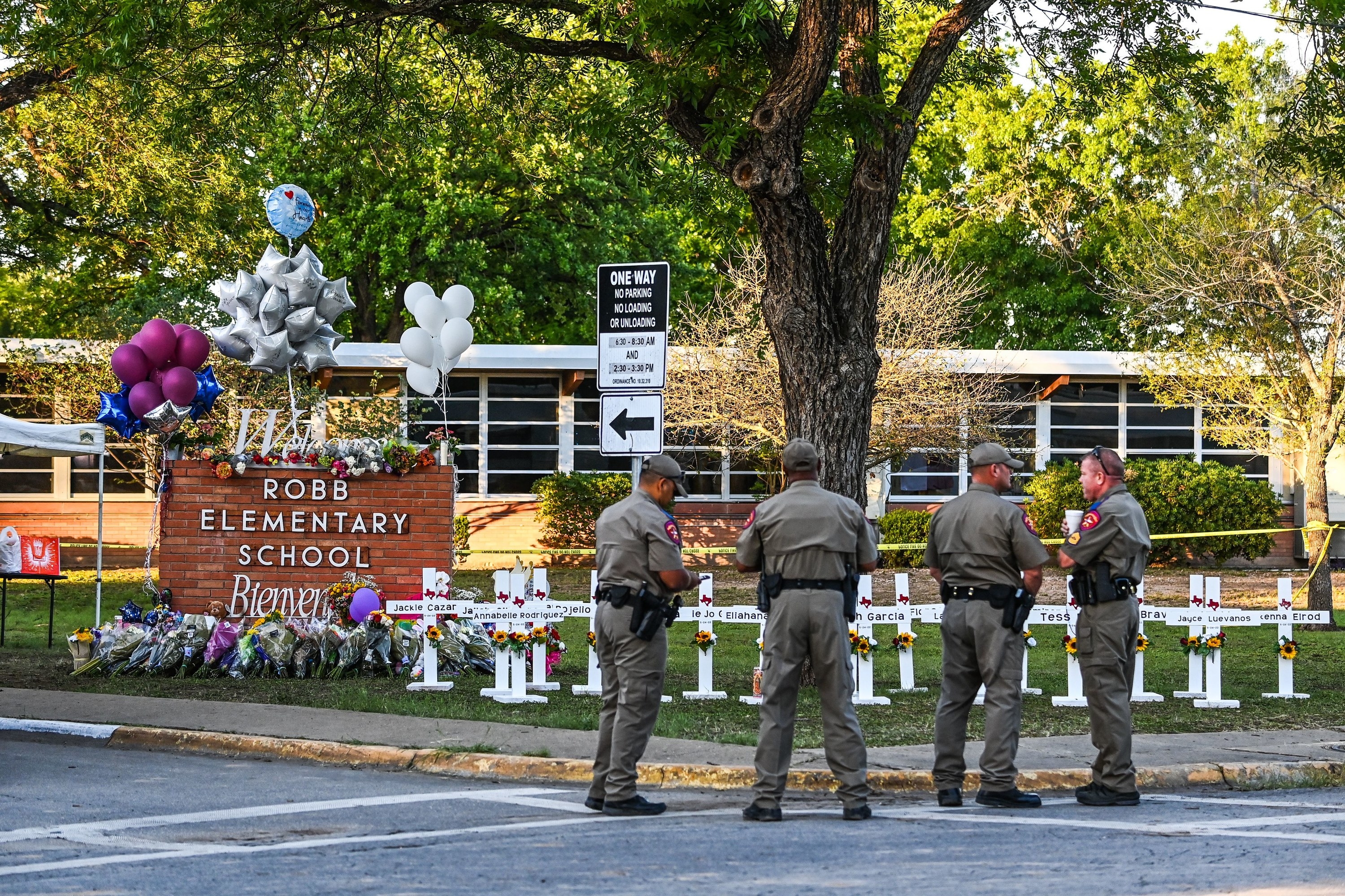 Police officers stand near a makeshift memorial for the shooting victims at Robb Elementary School in Uvalde, Texas, on May 26, 2022
