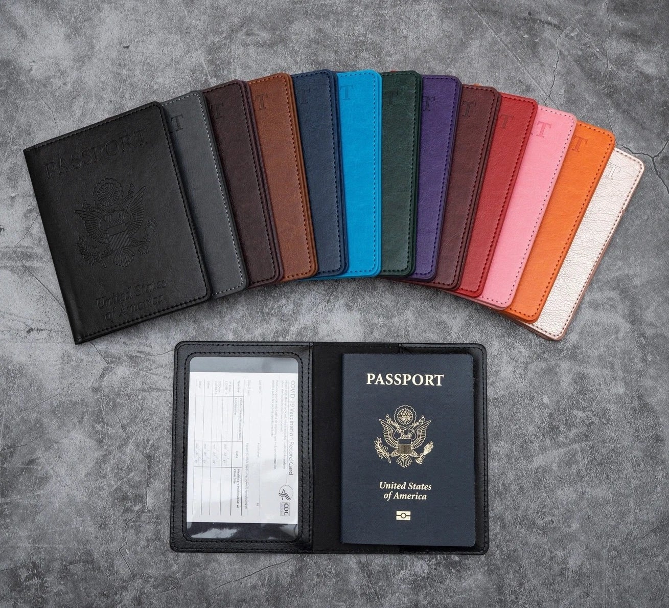the colorful passport holders fanned out above an open one that&#x27;s holding a vaccination card and passport