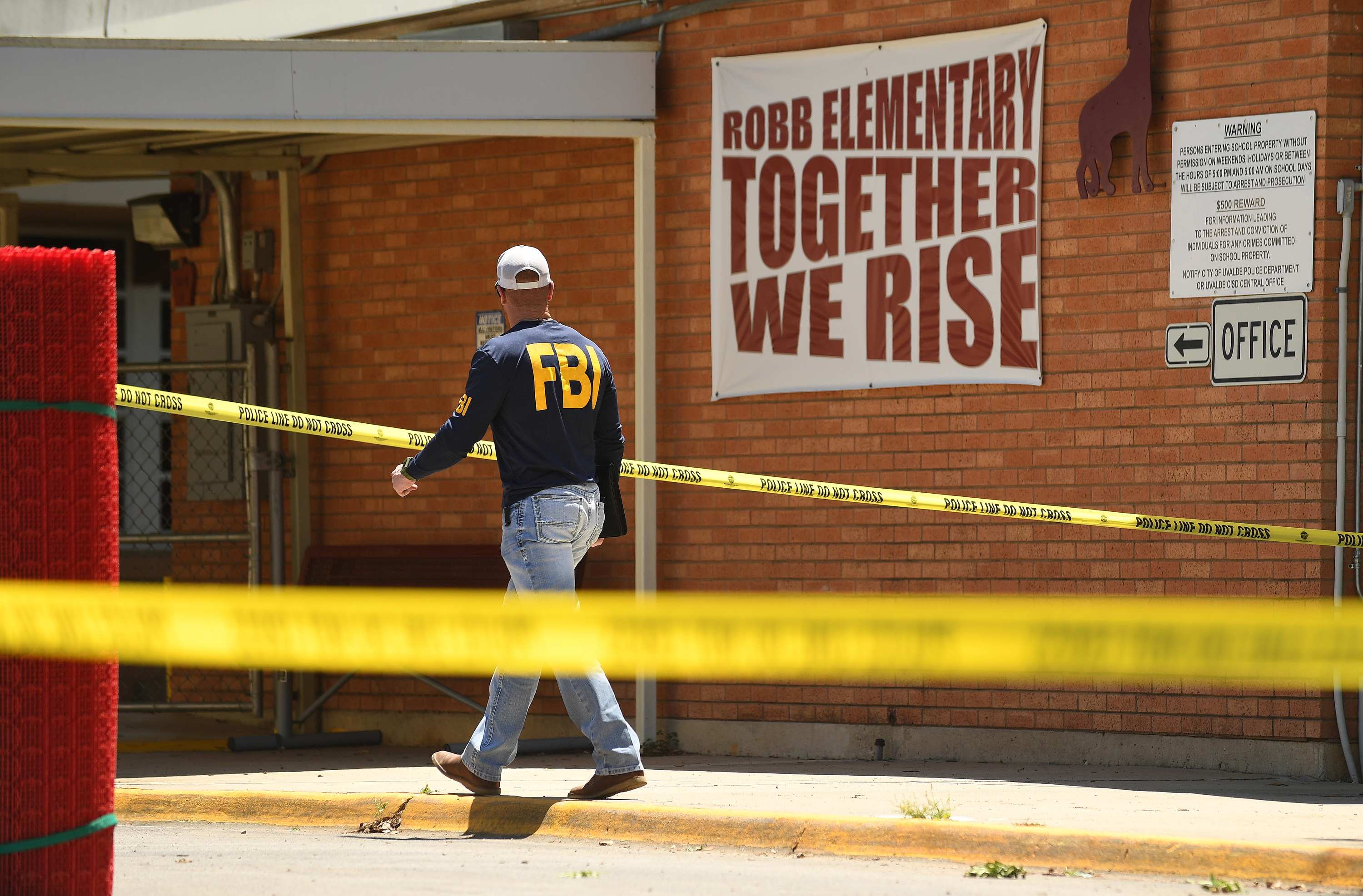 An FBI agent walks by the outside of Robb Elementary School in Uvalde, Texas Wednesday May 25, 2022.