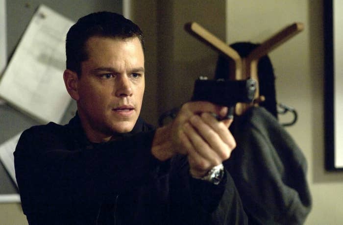 A close up of Jason Bourne as he holds a gun