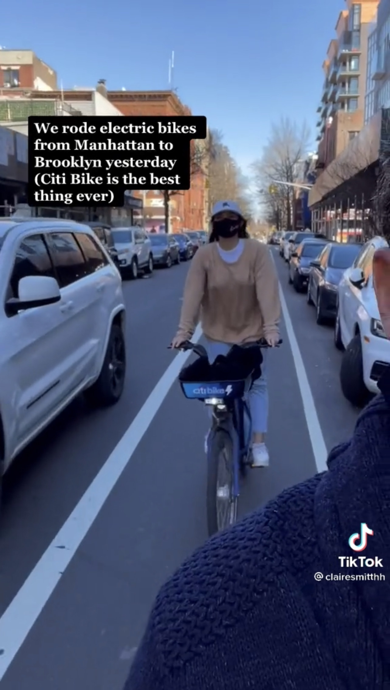 Woman riding Citi Bike with text saying they rode electric bikes from Manhattan to Brooklyn