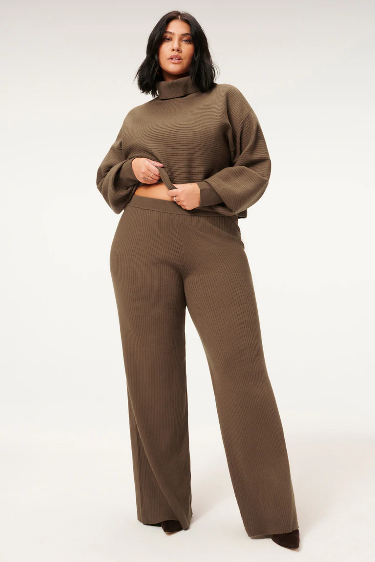 A person wearing a ribbed pants and a matching turtleneck sweater