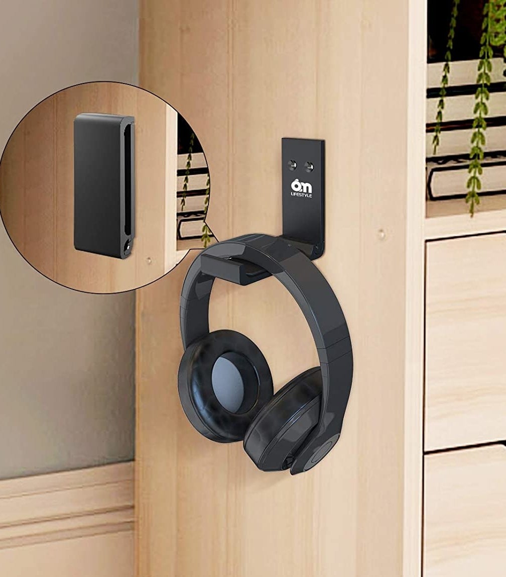 a pair of headphones hung on the wall mounted holder