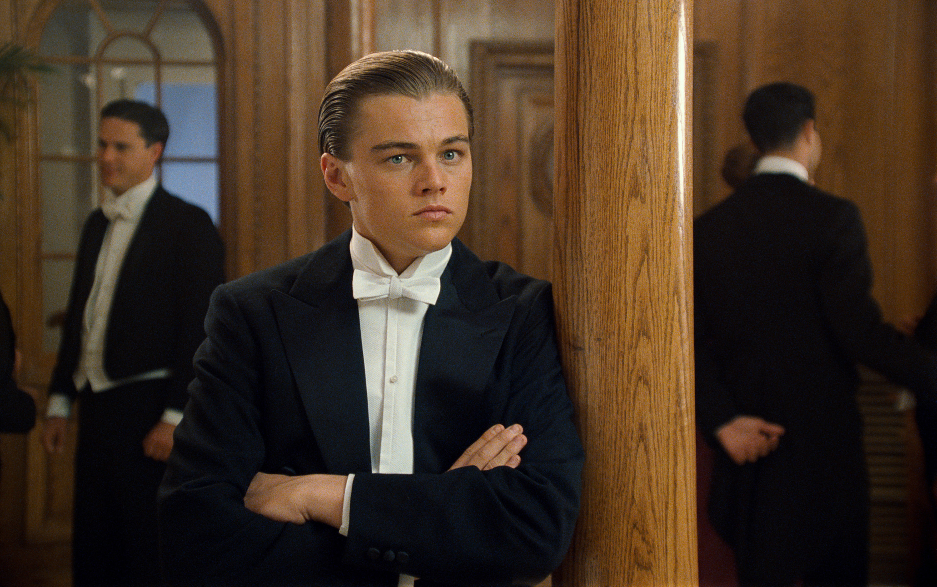 Leonardo in the film with his arms crossed and wearing a bow tie
