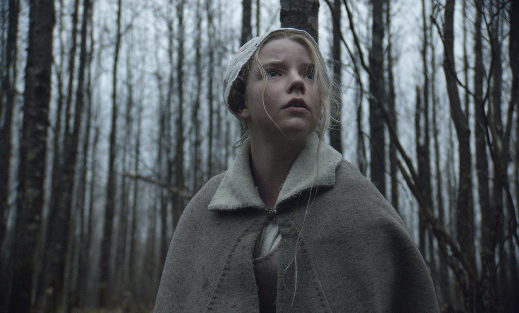 Anya Taylor-Joy stands in the woods
