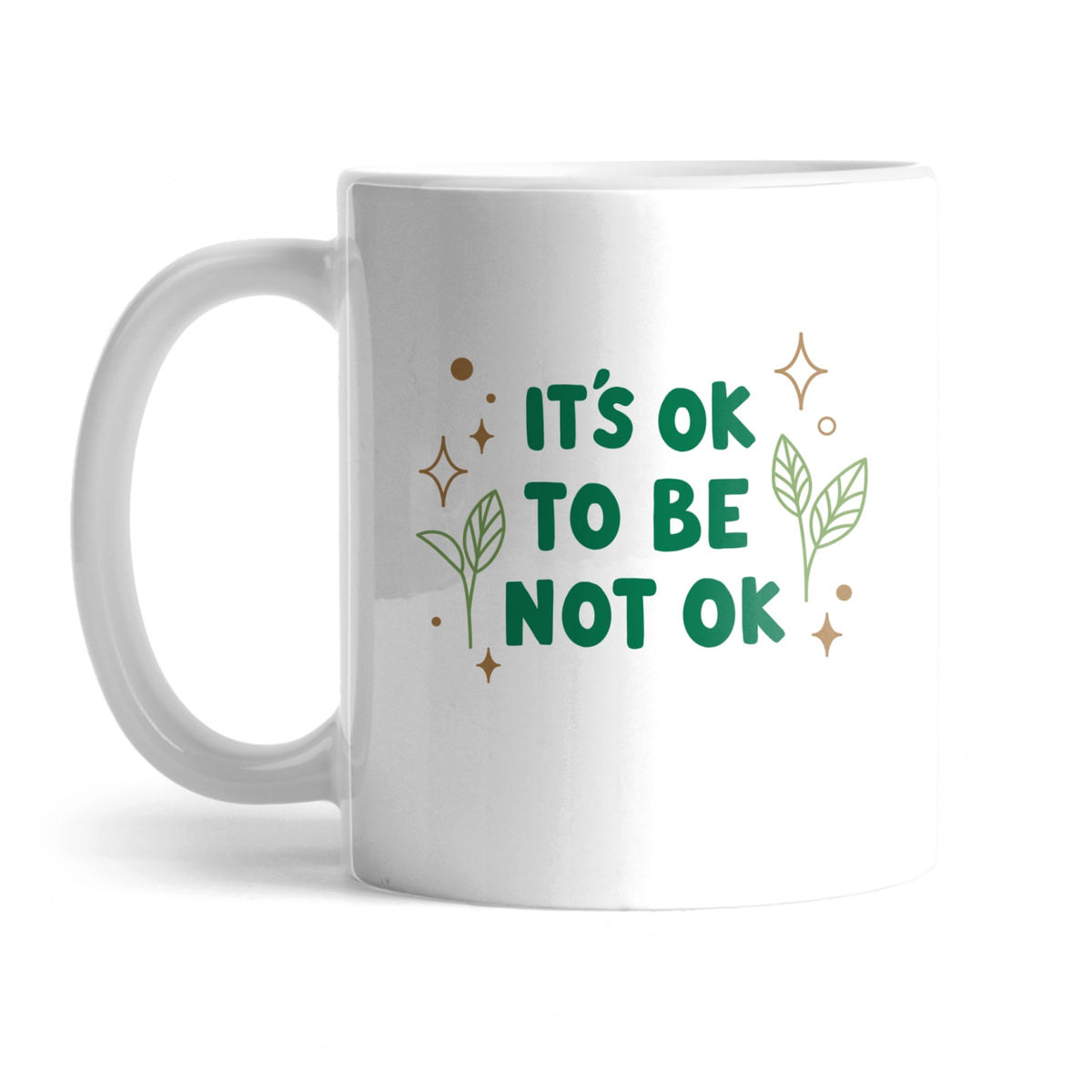 the white mug with &quot;it&#x27;s ok to not be ok&quot; in green text with green and brown leaves and sparkles