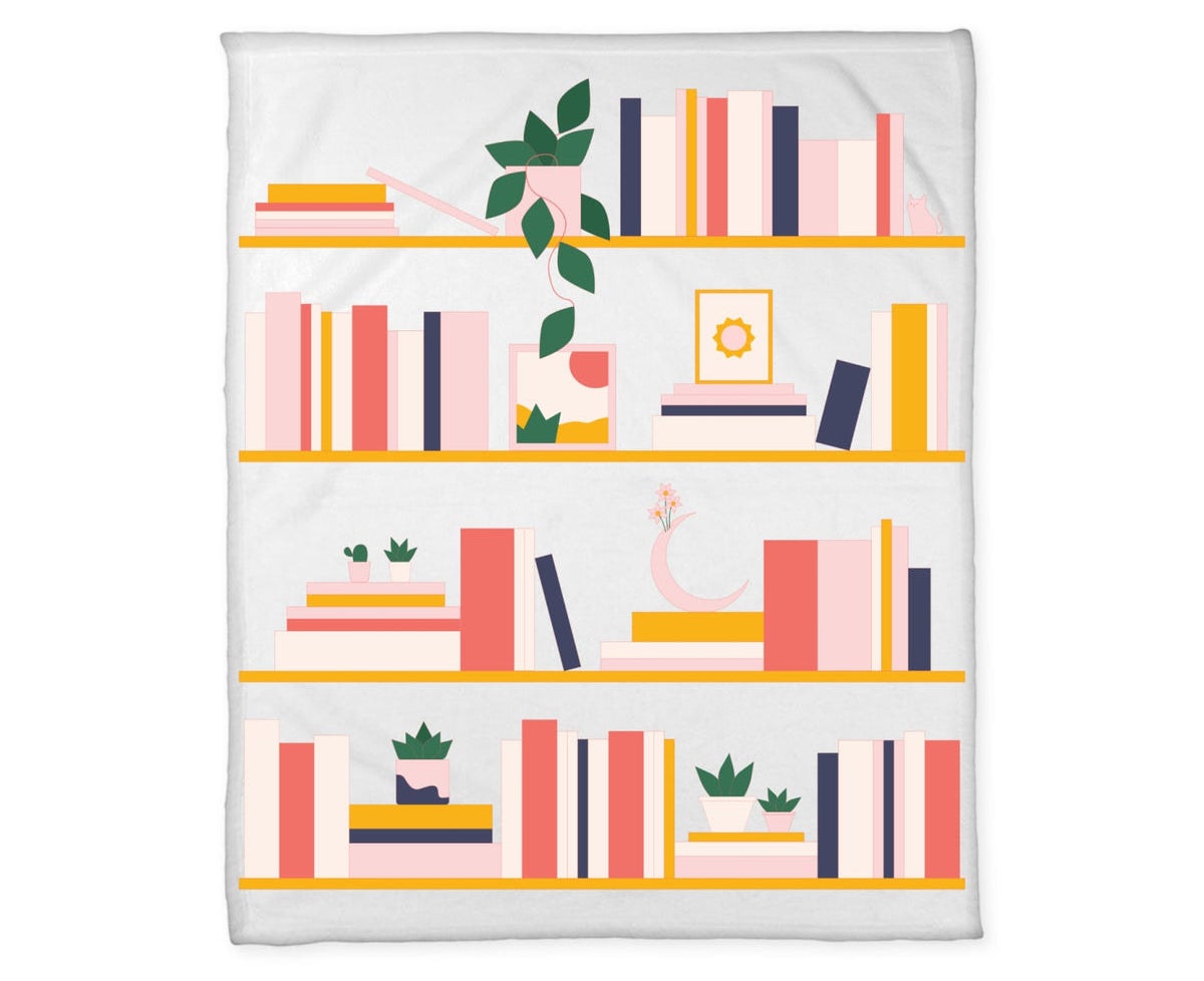 the light blue blanket with a drawing of a bookshelf in mostly pink and orange