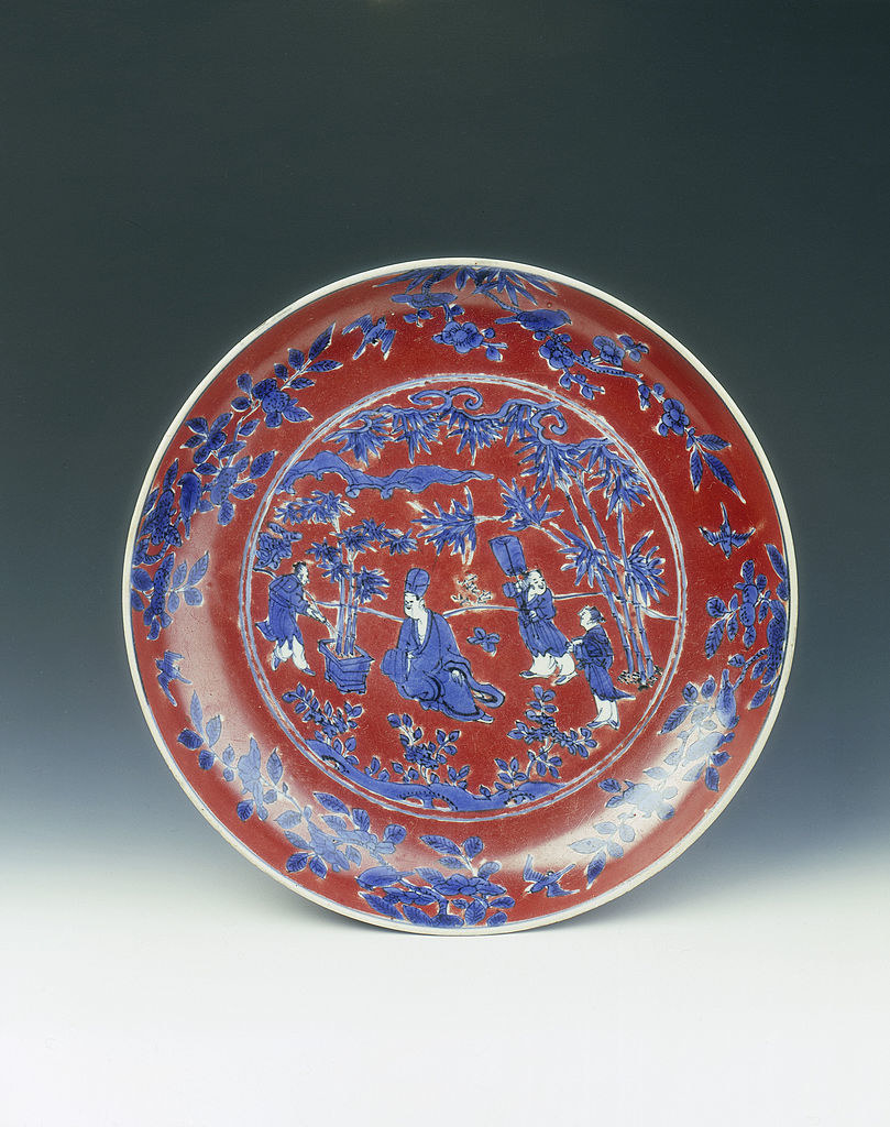 a large plate with floral design with four people at the center