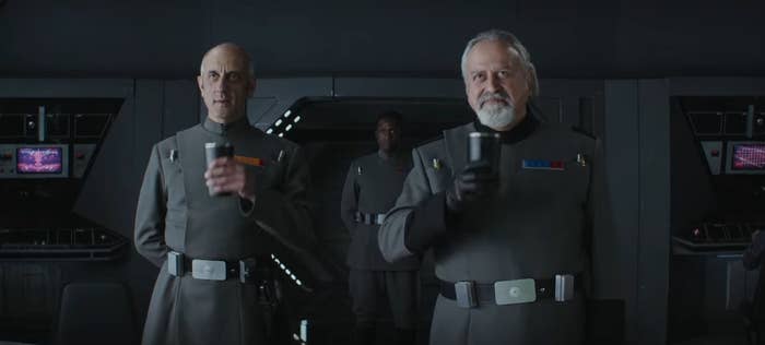 Two Imperial officers holding up cups in &quot;Andor&quot;