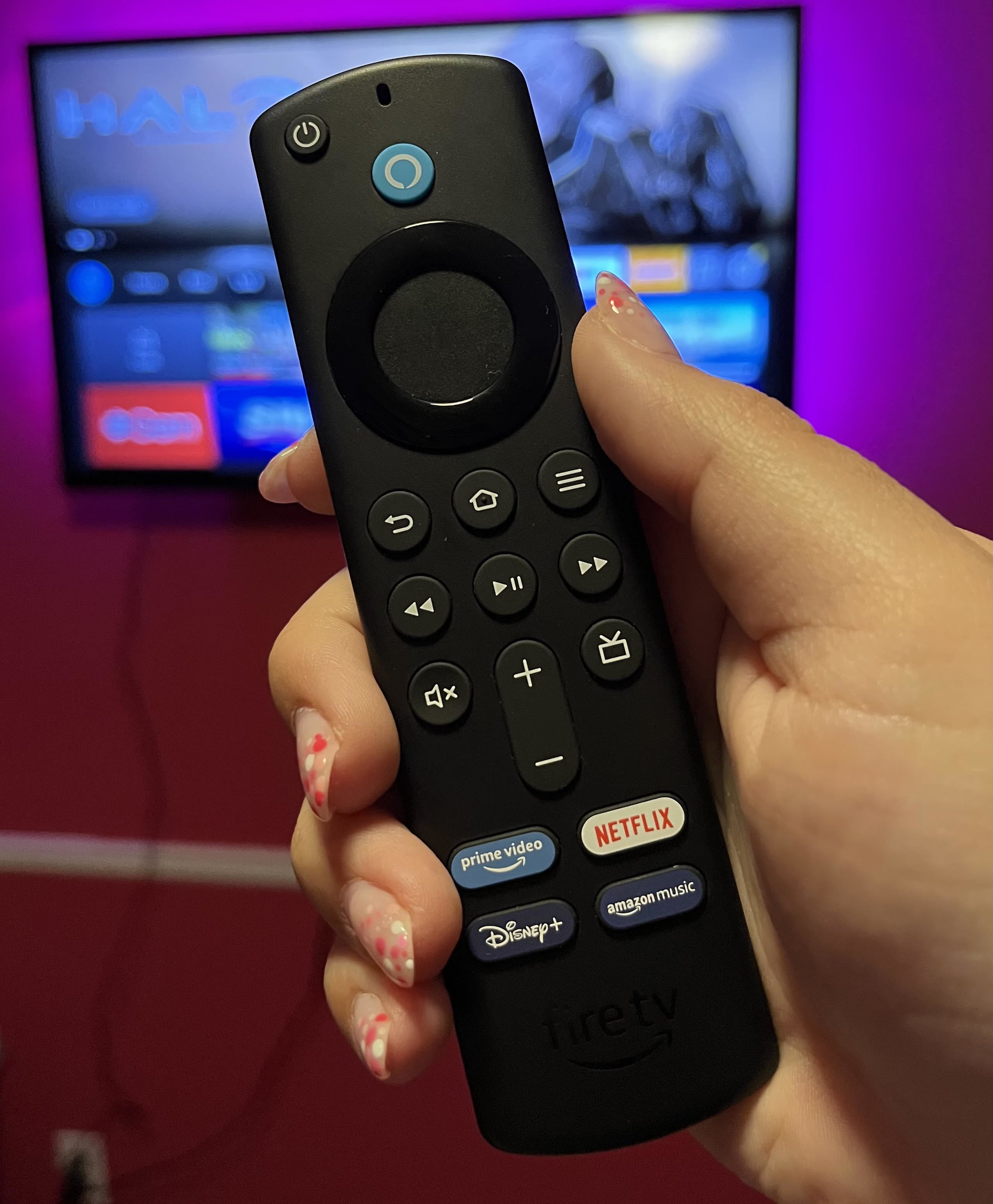 Bianca holding up the Fire TV Stick remote in front of the television