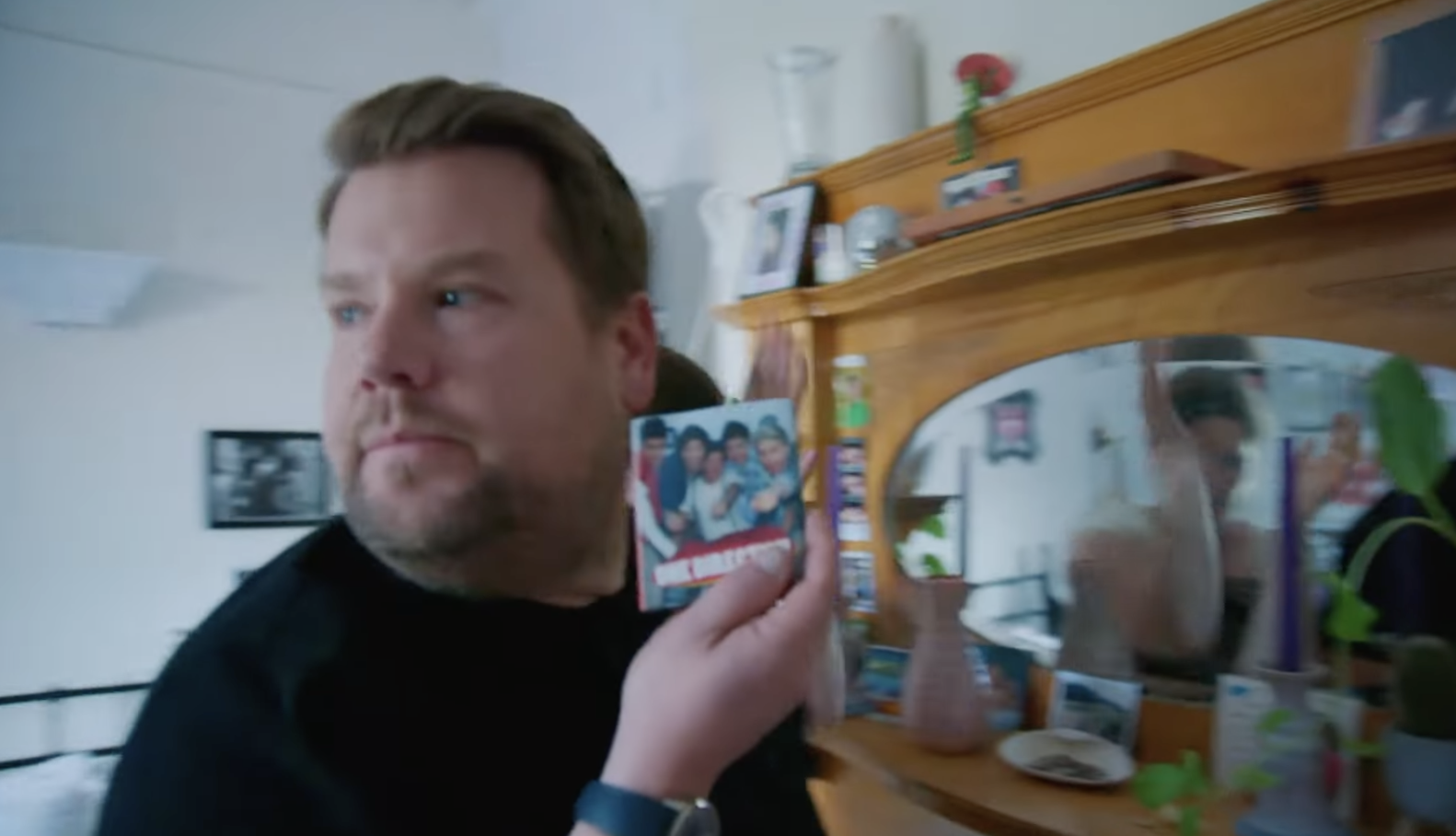 Corden holds up an object and looks at the woman disapprovingly