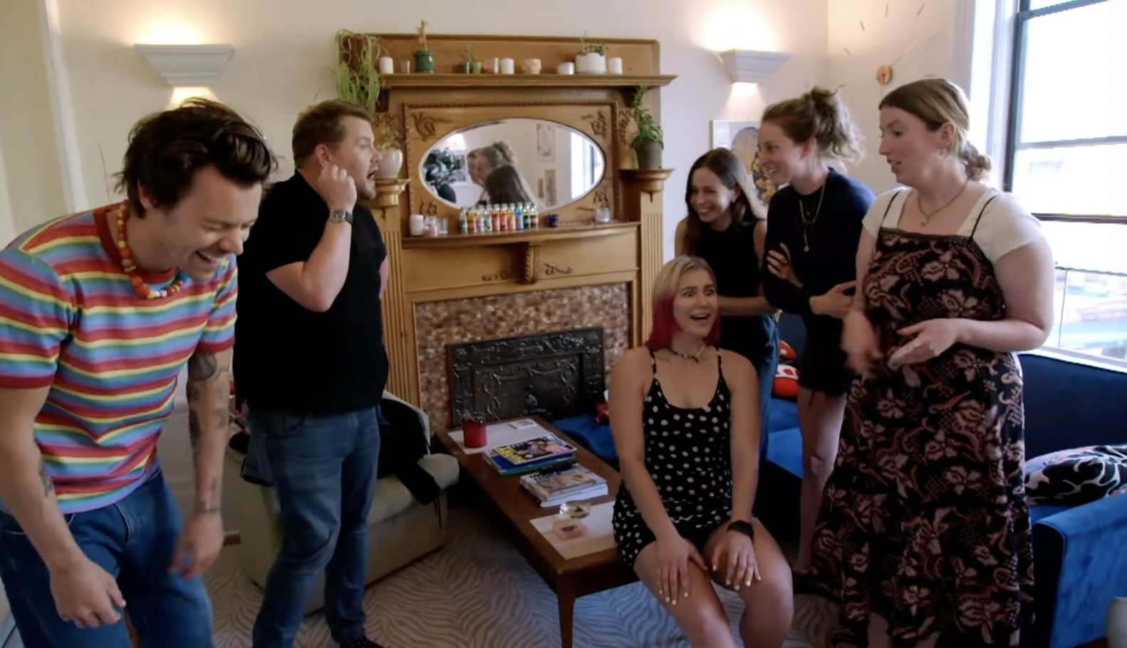 Styles laughs, Corden yells, and the four women look rattled in their apartment living room