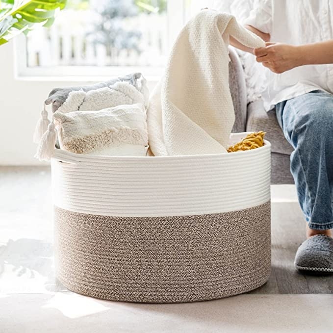 The basket in a room with blankets and pillows stored inside of it