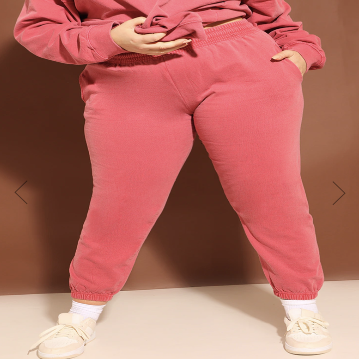 A person wearing a pair of joggers against a plain background