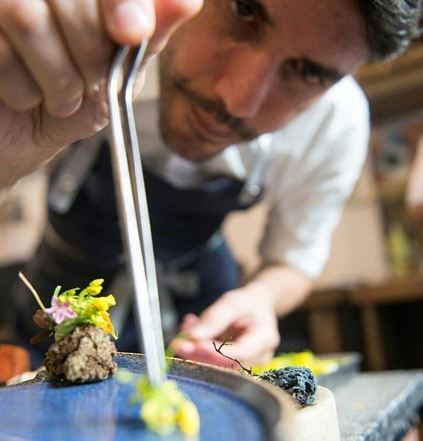 A chef plating a fancy dish of food