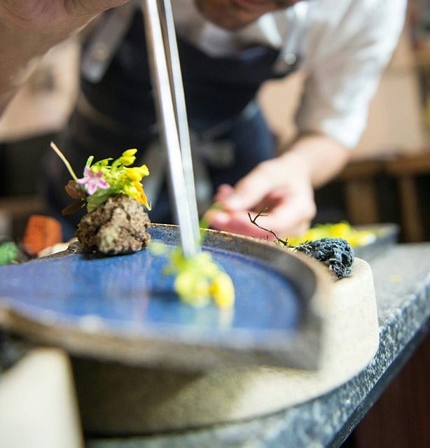A chef plating a fancy dish of food