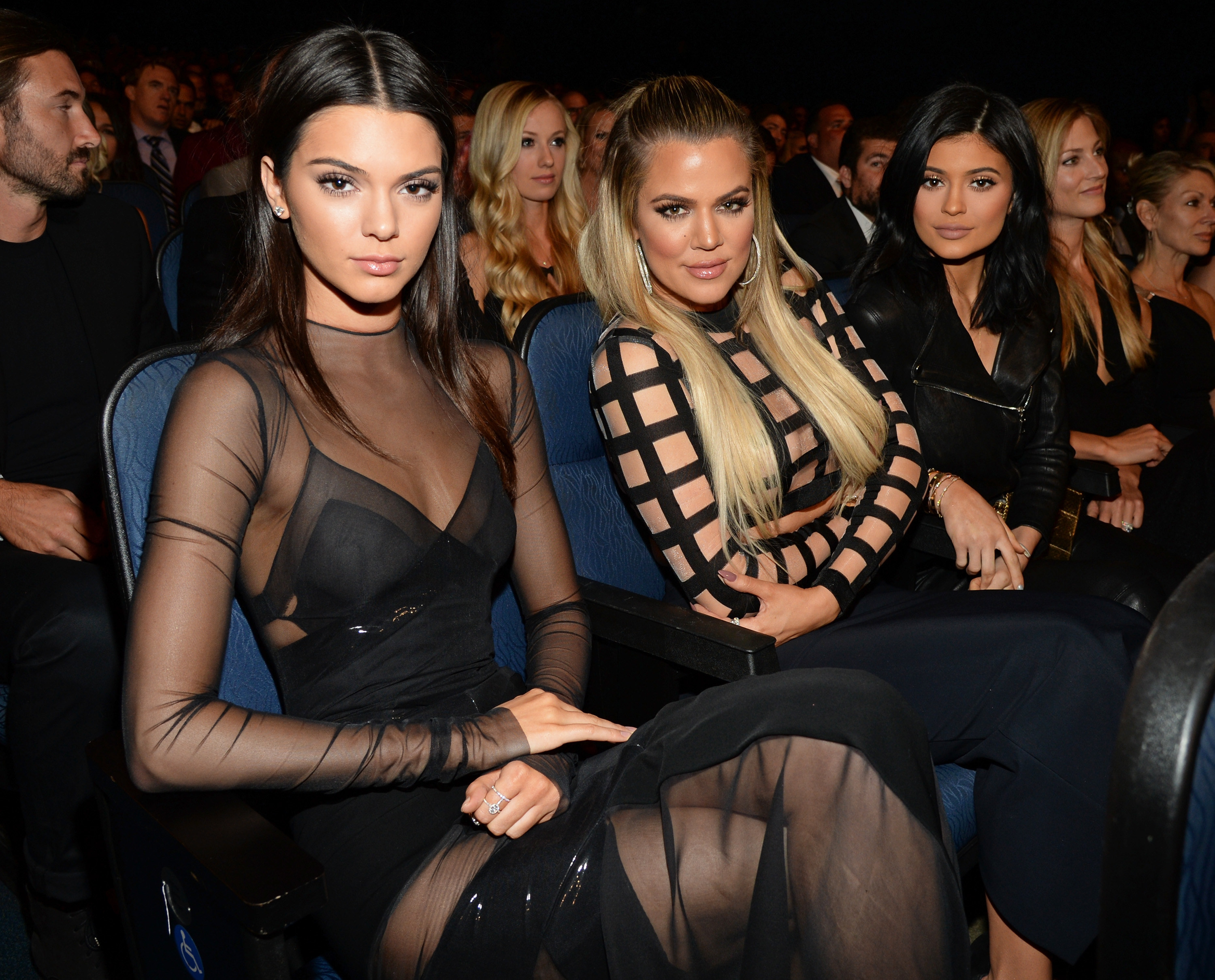 Kendall Jenner, Khloé Kardashian, and Kylie Jenner sit in a seated row at an event