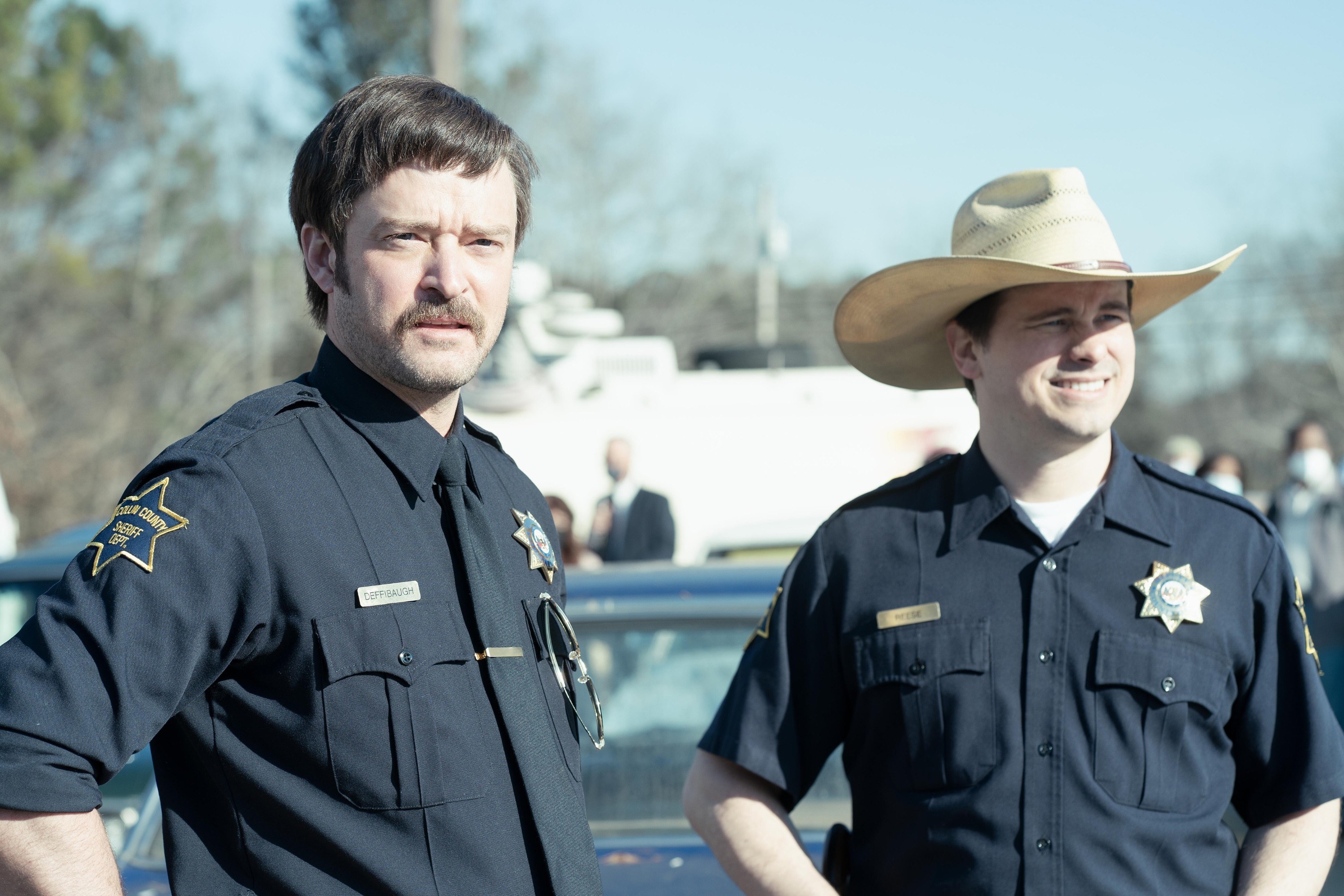 Justin and Jason in police uniforms, Justin with a moustache and Jason wearing a cowboy hat