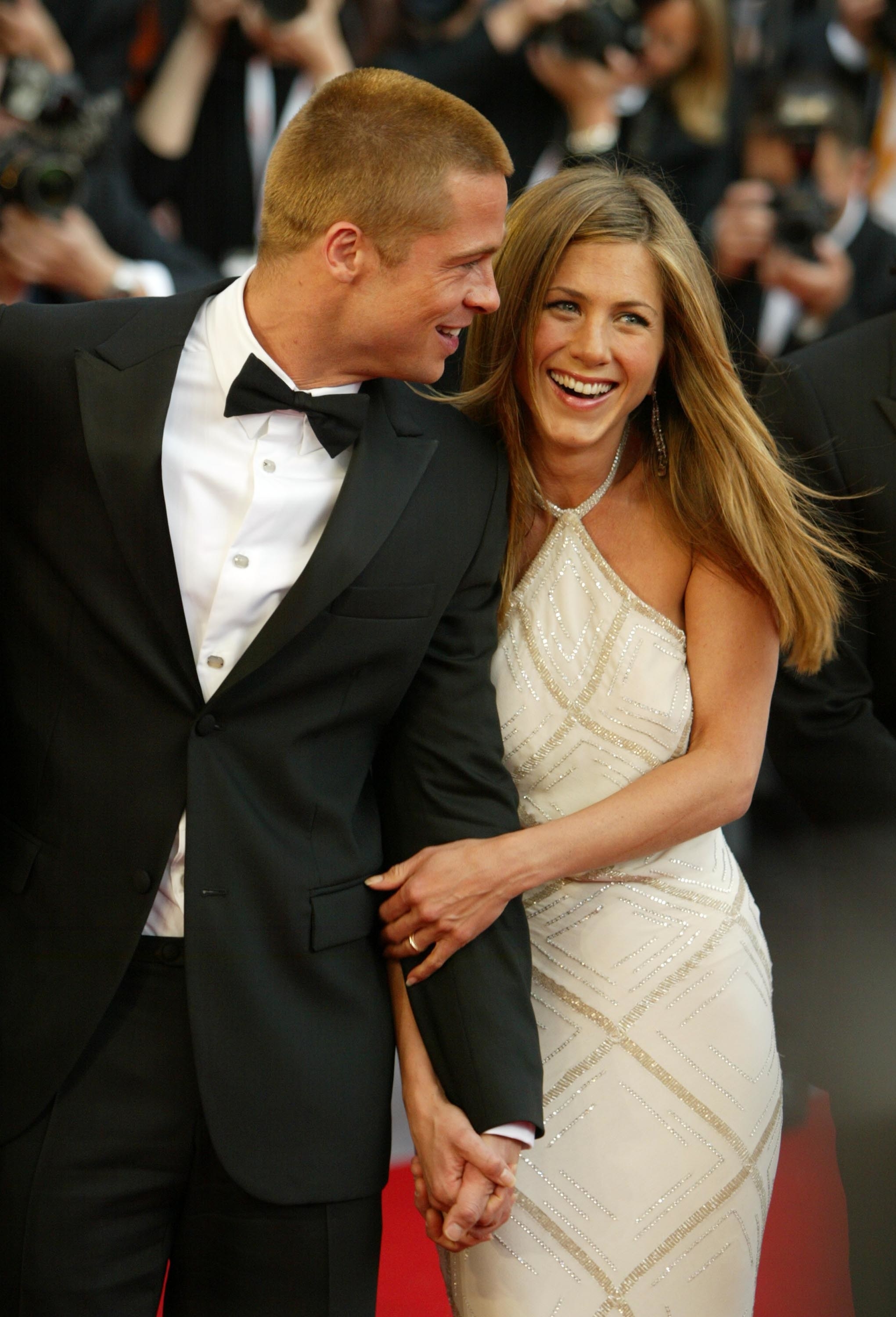 A smiling Brad Pitt and Jennifer Aniston on a red carpet