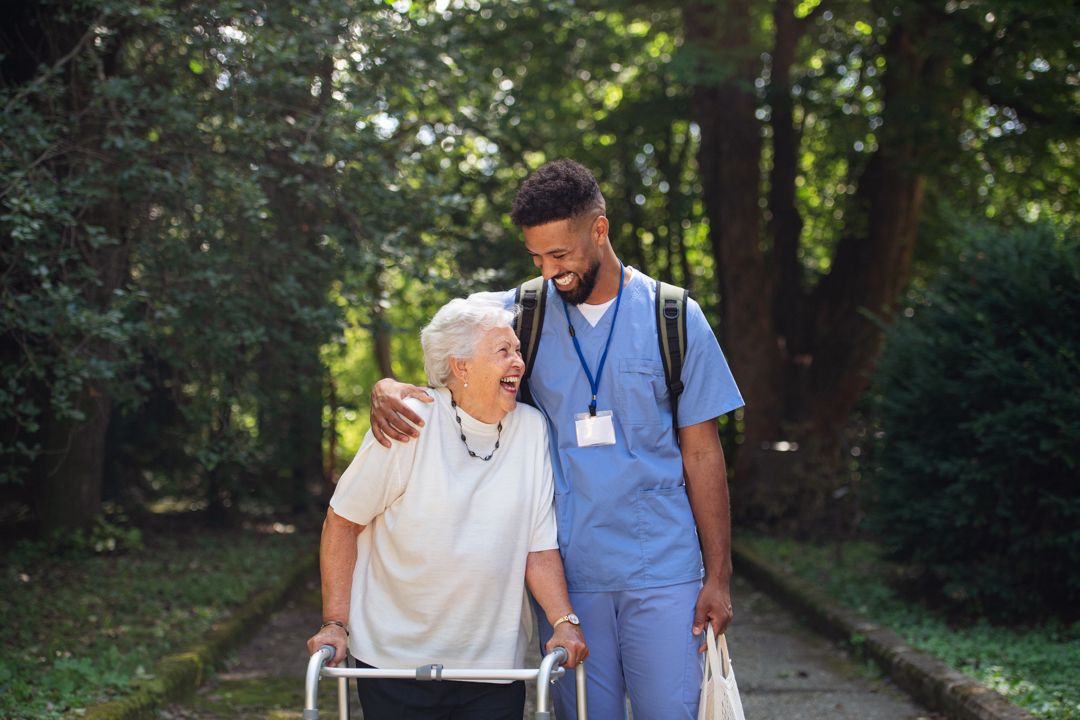 A nurse walking outside with a senior