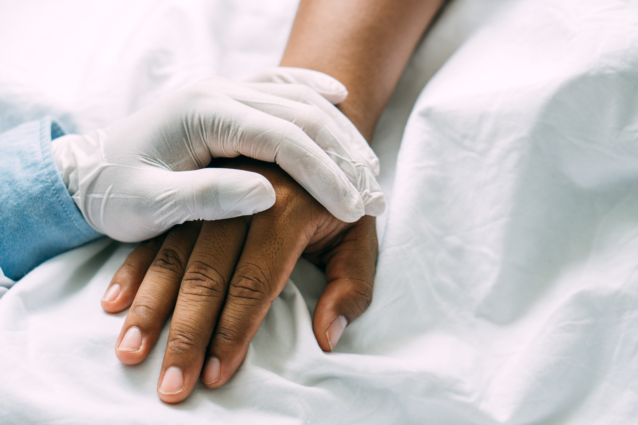 A medical professional&#x27;s hand on a patient&#x27;s hand