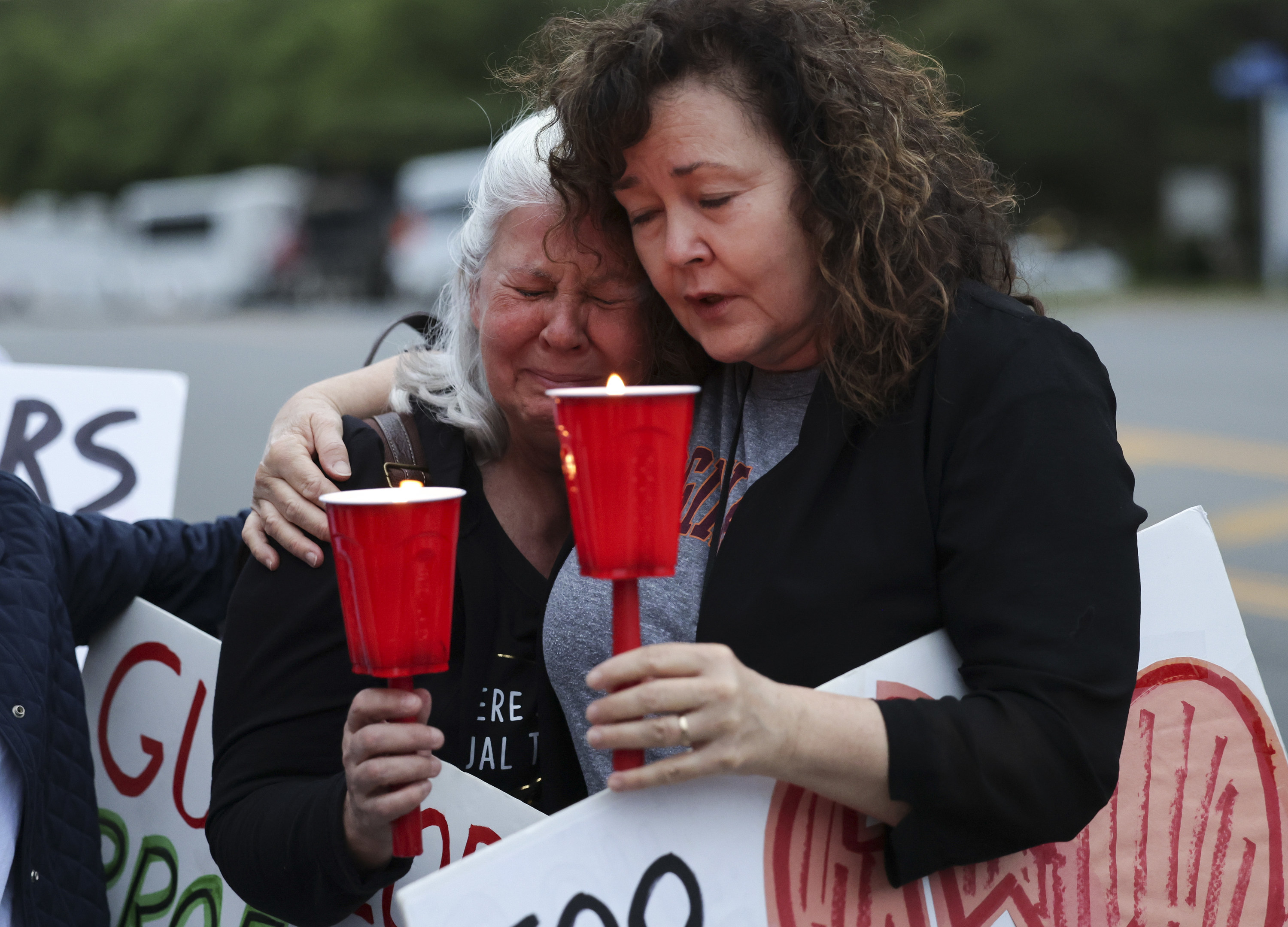women hugging and weeping at a vigil following the Uvalde shooting