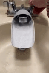 Gif of water flowing through a faucet extender attached to a faucet