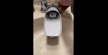 Gif of water flowing through a faucet extender attached to a faucet