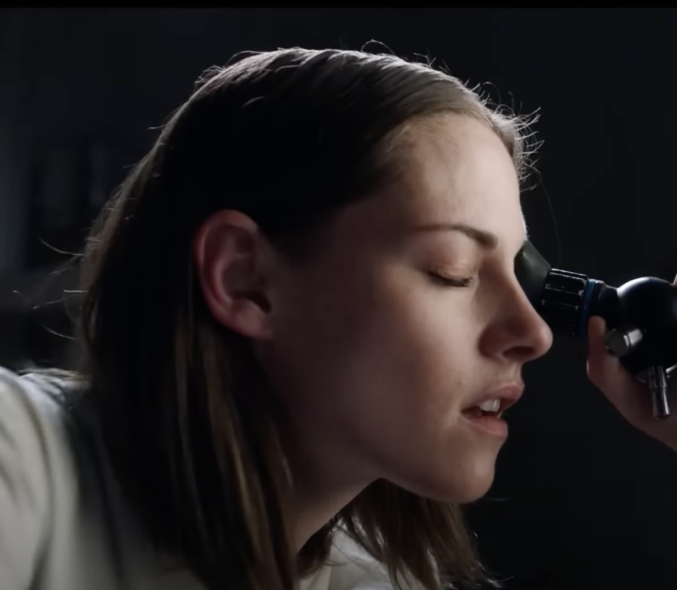 Kristen leans into a microscope in a scene from the trailer of Crimes of the Future