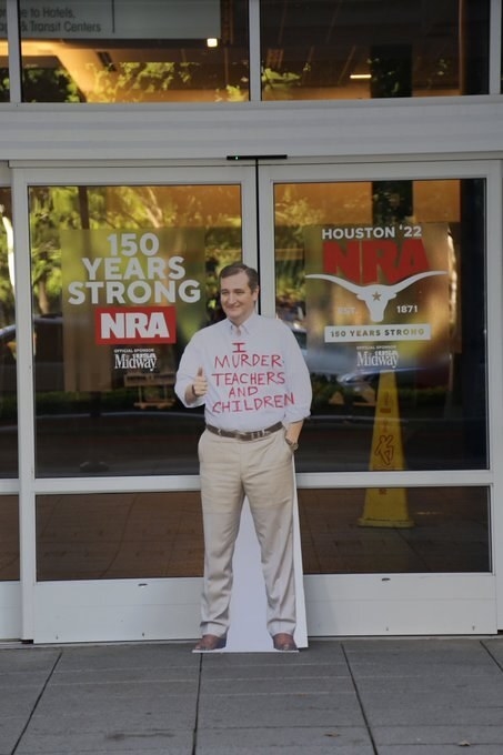 Cutout of smiling Ted Cruz with the words &quot;I murder teachers and children&quot;