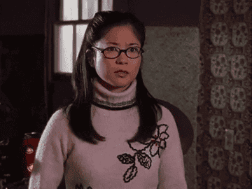 A bespectacled Asian woman is seen trying to say something