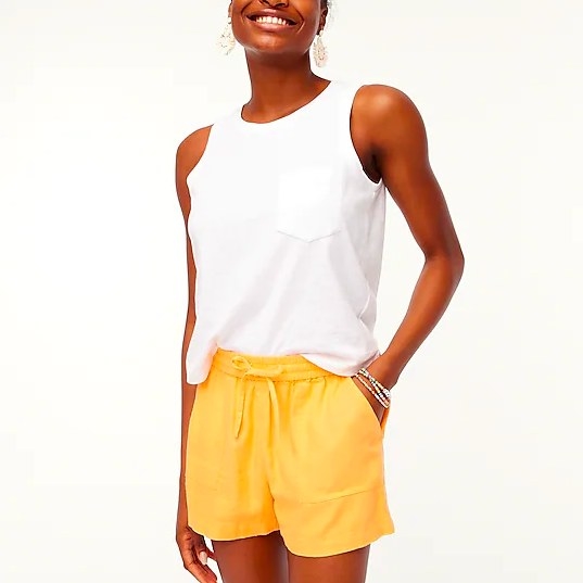 Model wearing yellow shorts and white tank