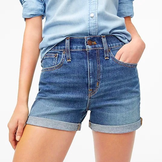 Model wearing denim shorts with tucked in chambray shirt