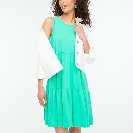 Model wearing mint colored mini dress and white denim jacket