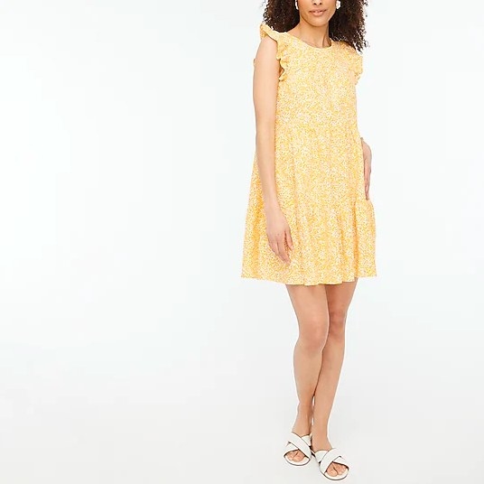 a model wearing the yellow floral dress with white sandals