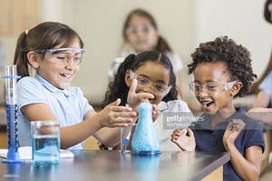Some very happy students create a foamy blue geyser in chemistry class; image credit to SDI productions via Getty Images