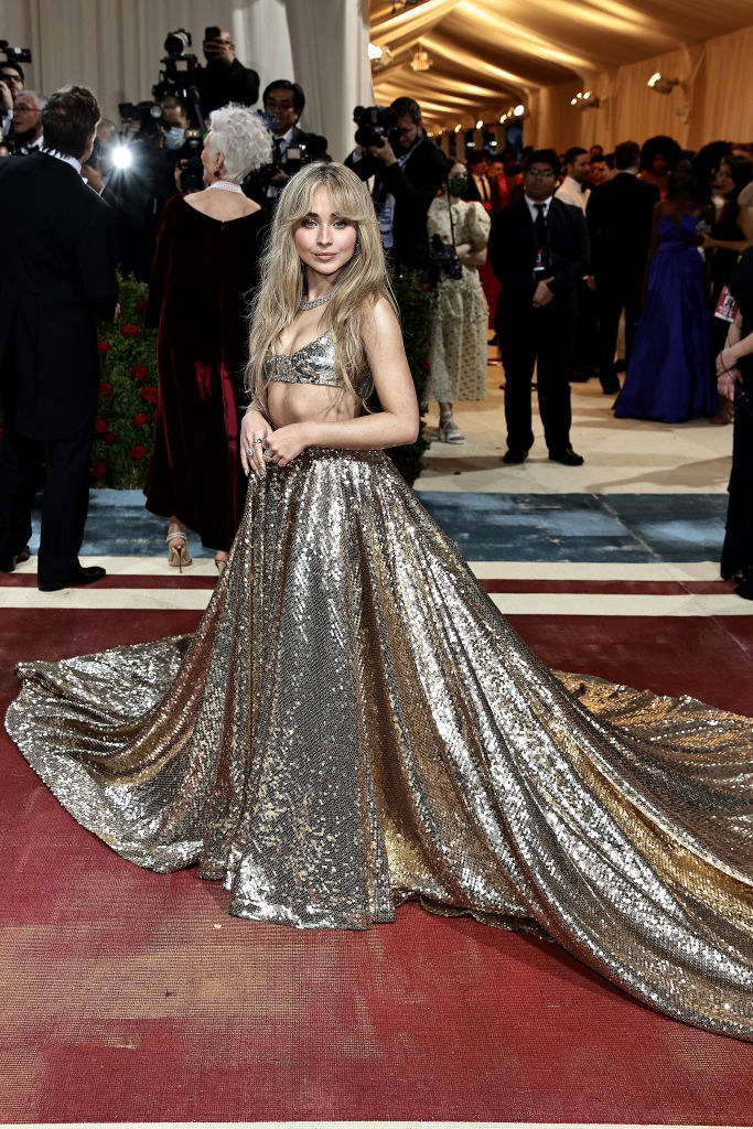 Sabrina Carpenter wearing a shimmery gown with a long train