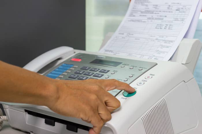 A person using a fax machine.