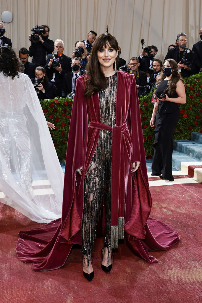 Dakota Johnson in a jumpsuit and velvet robe with a train
