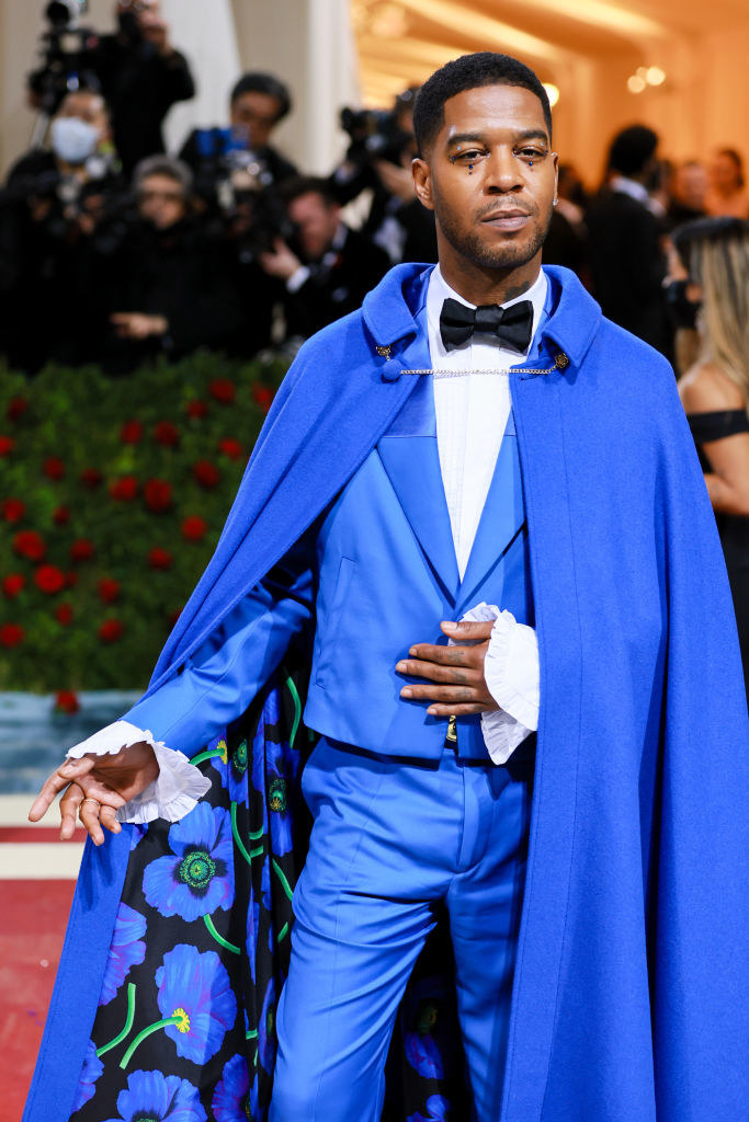 Kid Cudi in a bright blue tux and cape with floral lining