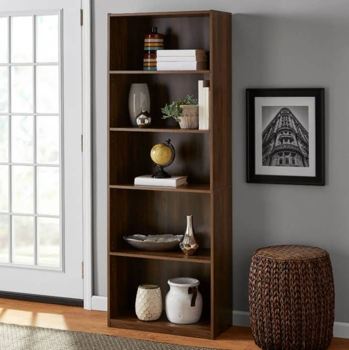 An image of a canyon walnut five-shelf bookcase with two fixed and three adjustable shelves that can hold up to 35 to 50 pounds