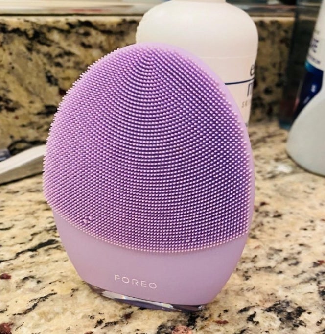 A reviewer&#x27;s purple device  on a bathroom counter