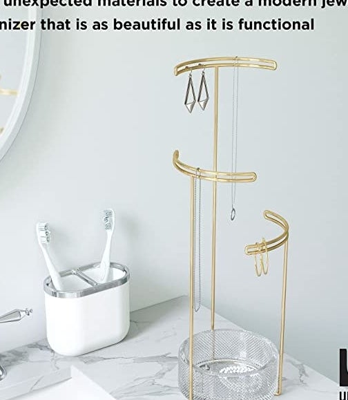 The jewellery stand on a counter next to a sink