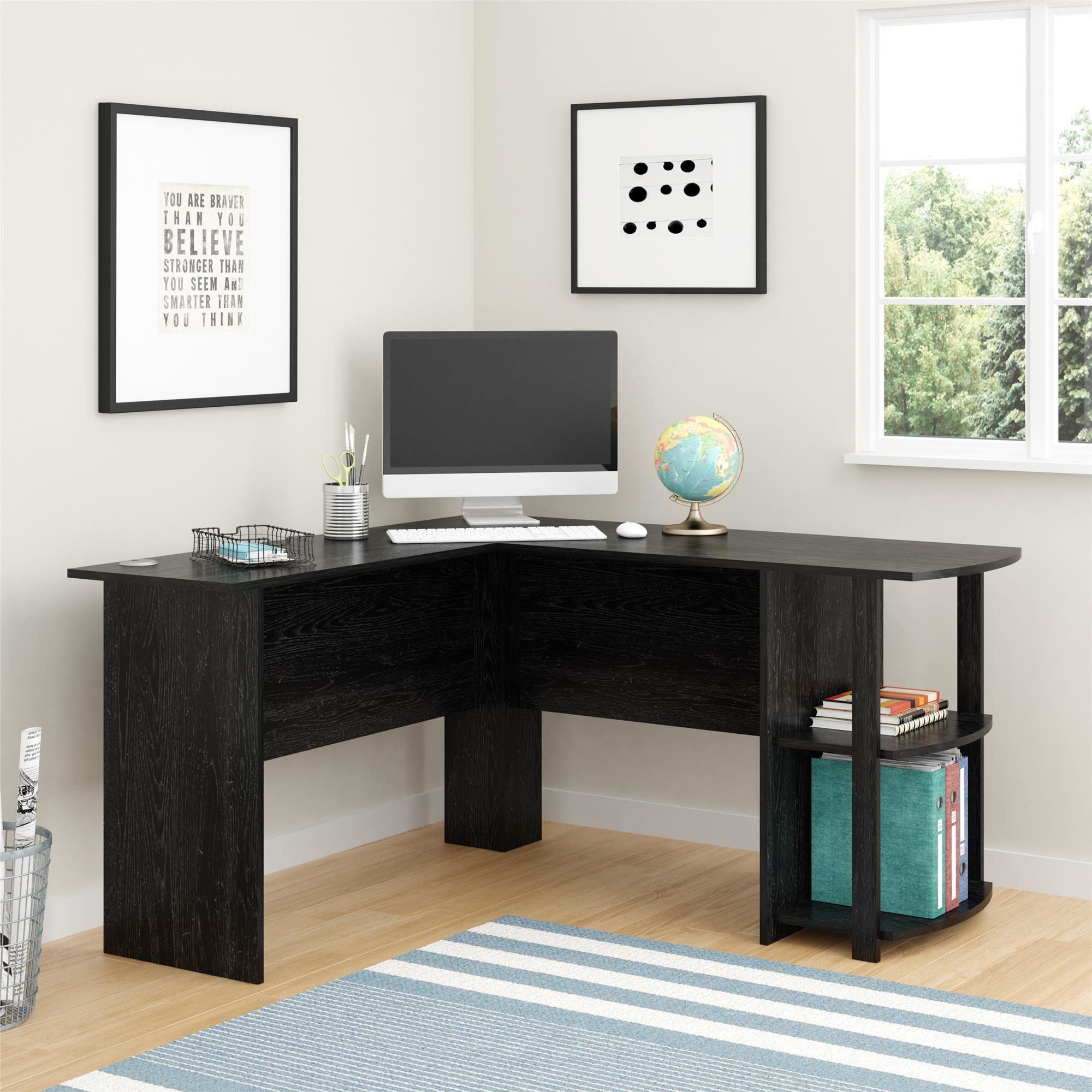 An image of a black oak L-shaped desk with built-in shelves and two grommets to organize and manage cords from devices