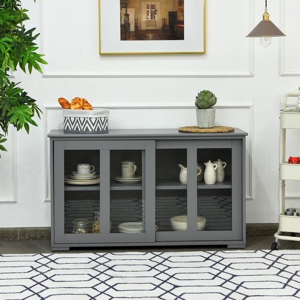 An image of a buffet cupboard with a sliding door and a height-adjustable storage shelf