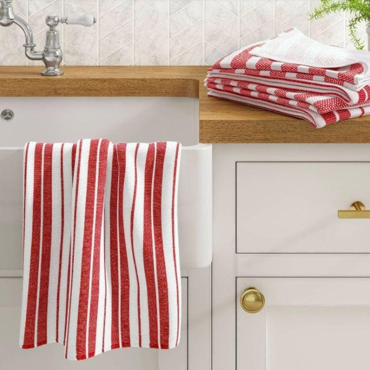 Striped red and white dishtowel hanging over a white farmhouse sink