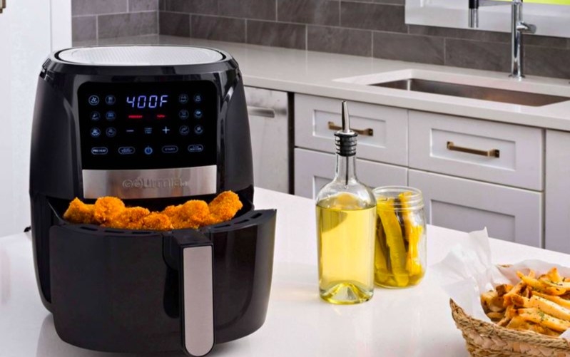 Air fryer filled with fried chicken on a kitchen countertop