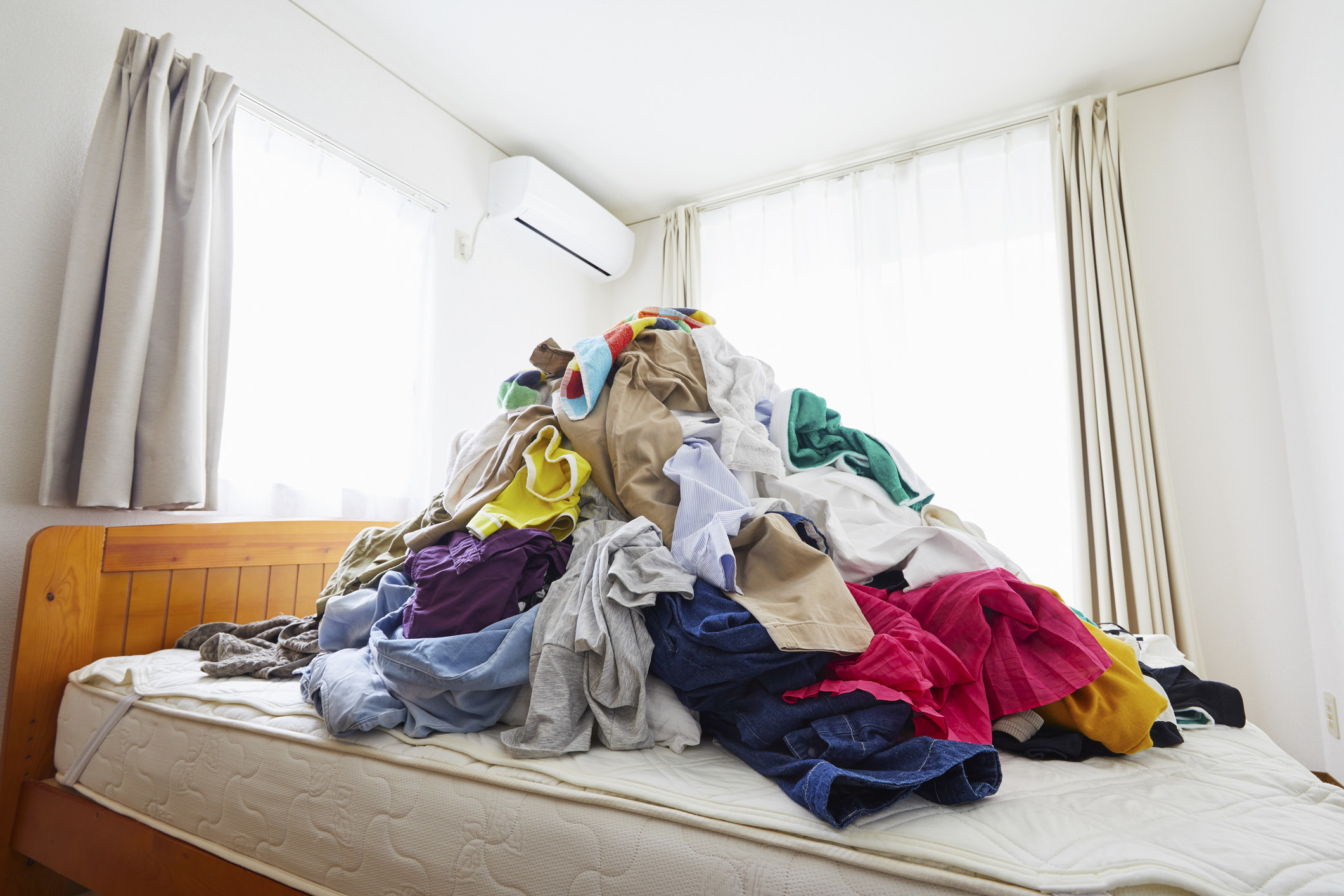 A pile of clothes sitting on the bed.