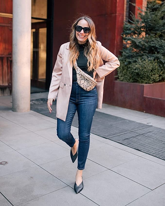 a person wearing the faux snakeskin belt bag with a blazer and jeans