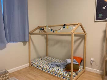 reviewer's photo of the wooden bed